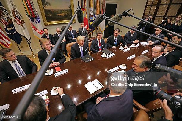 President Donald Trump leads a meeting with invited business leaders and members of his staff in the Roosevelt Room at the White House January 23,...