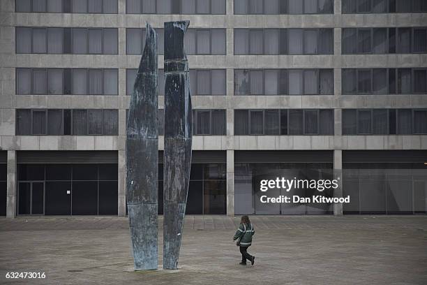 Traffic warden walks past a sculpture near office blocks on January 23, 2017 in Milton Keynes, England. Milton Keynes in Buckinghamshire marks the...