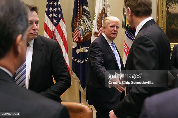 President Donald Trump greets Wendell Weeks of Corning, Elon Musk of SpaceX and other other business leaders as he arrives for a meeting in the...
