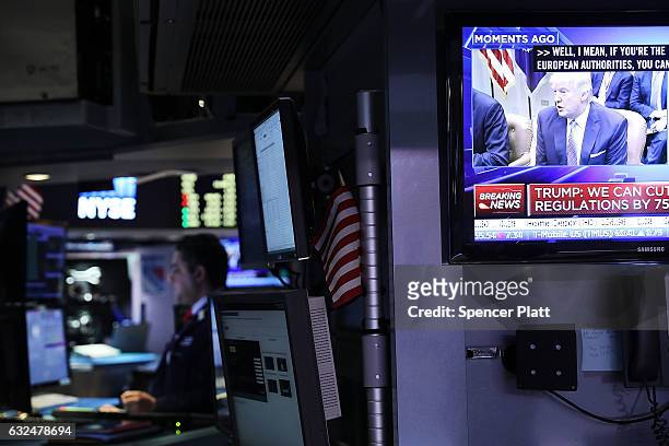 Television screen shows President Donald Trump as traders work on the floor of the New York Stock Exchange on the first day of trading after Donald...
