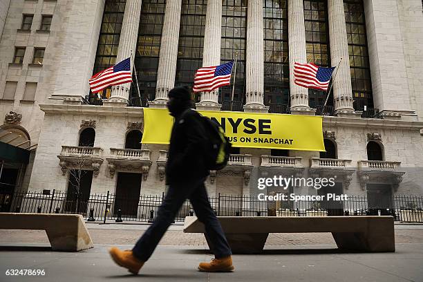 People walk by the New York Stock Exchange on the first day of trading after Donald Trump was sworn in as president on January 23, 2017 in New York...