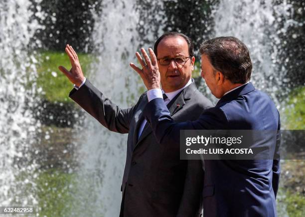 Colombian President Juan Manuel Santos and French President Francois Hollande talk during the latter's welcoming ceremony at Narino Palace in Bogota...