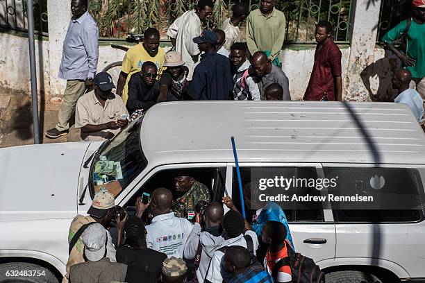 Crowd swarms the car of Ousman Badji, Gambia's Army chief, as he leaves the Gambian statehouse on January 23, 2017 in Banjul, The Gambia. Badji swore...