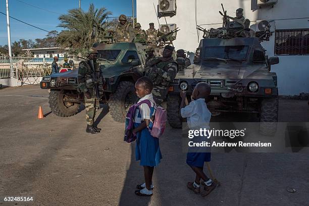 Children walk by a group of ECOWAS troops from Senegal stationed outside the Gambian statehouse on January 23, 2017 in Banjul, The Gambia. ECOWAS is...
