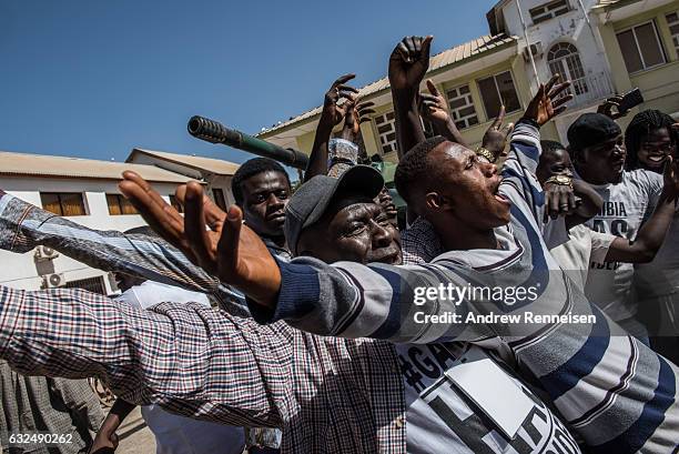 Men celebrate as ECOWAS troops from Senegal gather outside the Gambian statehouse on January 23, 2017 in Banjul, The Gambia. ECOWAS is in Gambia to...