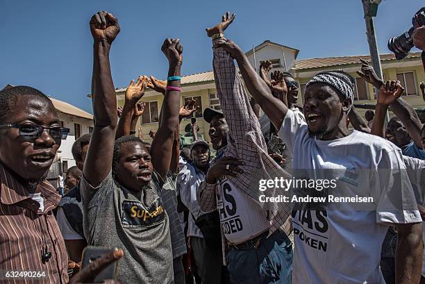 People celebrate as ECOWAS troops from Senegal gather outside the Gambian statehouse on January 23, 2017 in Banjul, The Gambia. ECOWAS is in Gambia...