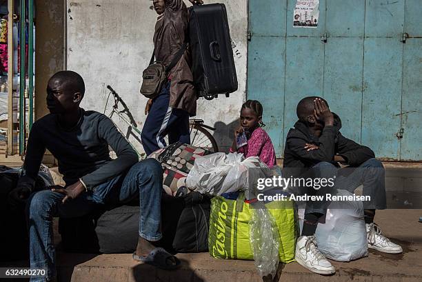 Ulhaji Sesay his sister, Fatemahta and brother, Jibril wait for their mother outside the Banjul Ferry Terminal after returning home on January 23,...