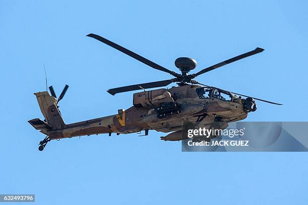 Picture taken on January 23 shows an Israeli AH-64 Apache Longbow helicopter flying over the Israeli coastal city of Hadera north of Tel Aviv. / AFP...
