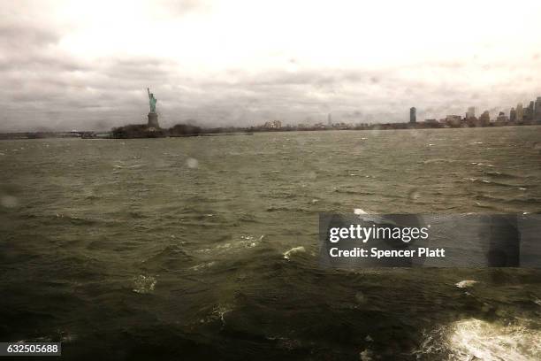 The Statue of Libery shows through a rain splattered window on the Staten Island Ferry as New York City prepares for a nor'easter storm on January...