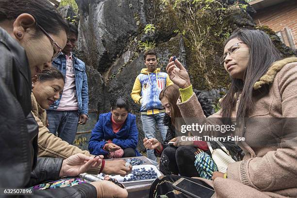 Gem buyers test the quality of gems before a private sapphire auction organized by a mine owner.