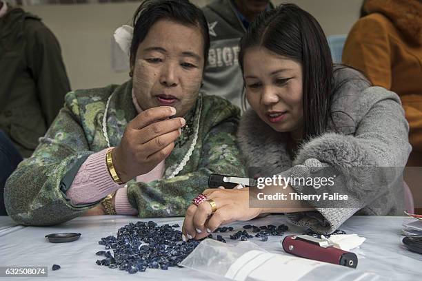 Gem buyers test the quality of gems before a private sapphire auction organized by a mine owner.