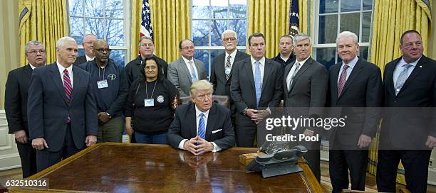 President Donald Trump poses for a group photo at a meeting with union leaders at the White House on January 23, 2017 in Washington, DC. President...