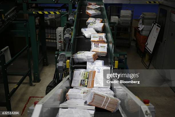 Bulk packages of direct mail advertising move down a conveyor belt before being sorted at the United States Postal Service sorting center in...