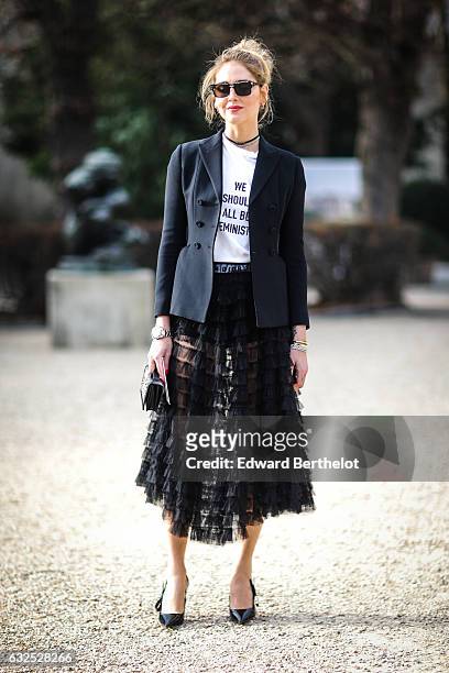 Chiara Ferragni wears sunglasses, a black blazer jacket, a white t-shirt with the inscriptions " We should all be Feminists", a black meshed dress,...