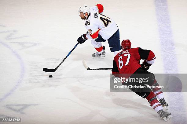 Jakub Kindl of the Florida Panthers skates with the puck past Lawson Crouse of the Arizona Coyotes during the first period of the NHL game at Gila...