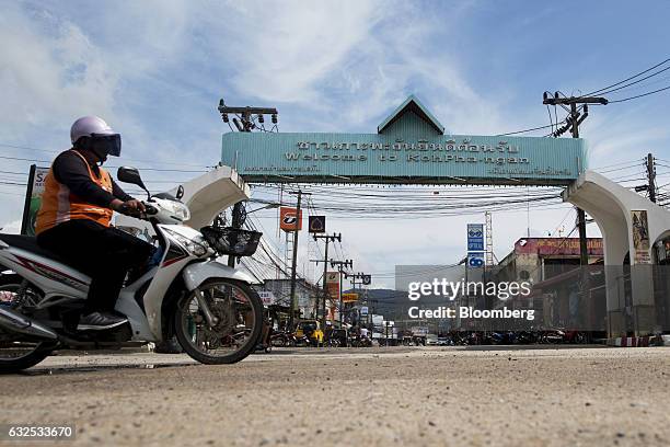 Motorcycle taxi drives past a sign that reads "Welcome To Koh Pha-Ngan" in Koh Phangan, Surat Thani, Thailand, on Wednesday, Jan. 18, 2017....