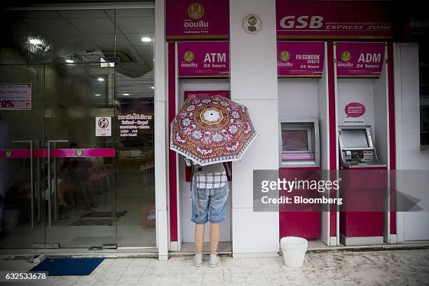 Tourist stands at a Government Savings Bank automated teller machine in Koh Phangan, Surat Thani, Thailand, on Tuesday, Jan. 17, 2017. Government...