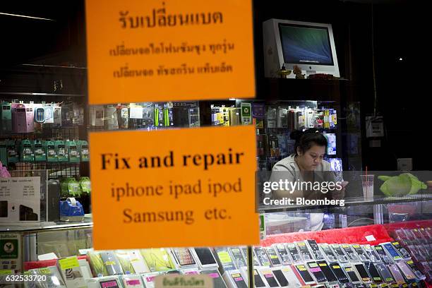 Vendor uses a smartphone in a second-hand mobile phone store in Koh Phangan, Surat Thani, Thailand, on Tuesday, Jan. 17, 2017. Government spending...