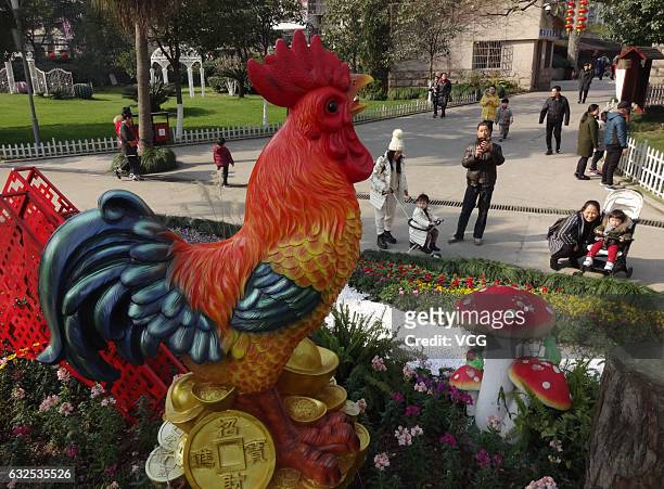 Tourists look at the sculpture of rooster at a park on January 23, 2017 in Wenzhou, Zhejiang Province of China. To welcome the Year of Rooster,...