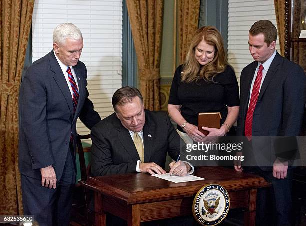 Representative Mike Pompeo, a Republican from Kansas, second left, signs the affidavit of appointment after being sworn-in as director of the Central...