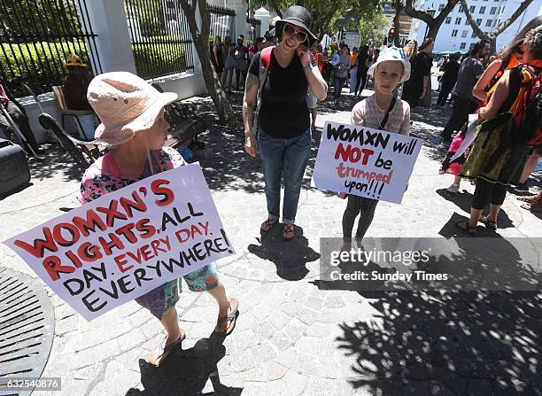 Protesters hold placards during a solidarity march with the Womens March on Washington on January 21, 2017 in Cape Town, South Africa. More than 1...