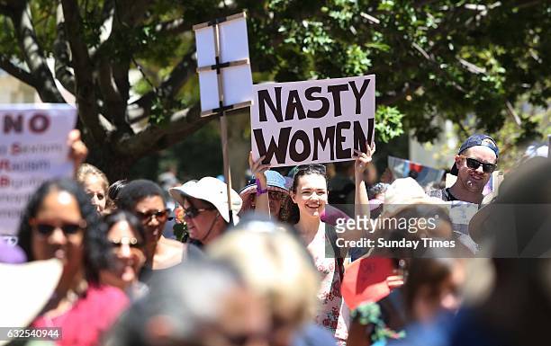 Protesters hold placards during a solidarity march with the Womens March on Washington on January 21, 2017 in Cape Town, South Africa. More than 1...