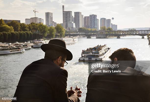 Two men in conversation on a bridge over the Siene river, 9th October 2016, Pont d'Iéna, Paris.