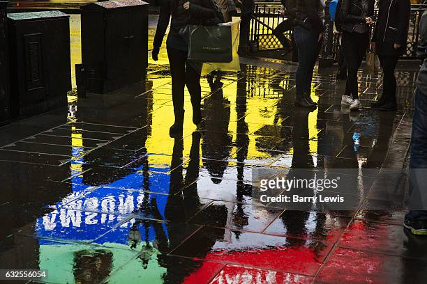 The brightly coloured advertising hoardings reflect off the wet pavement, on 4th November 2016, in Piccadilly Circus, London, England. The Circus is...