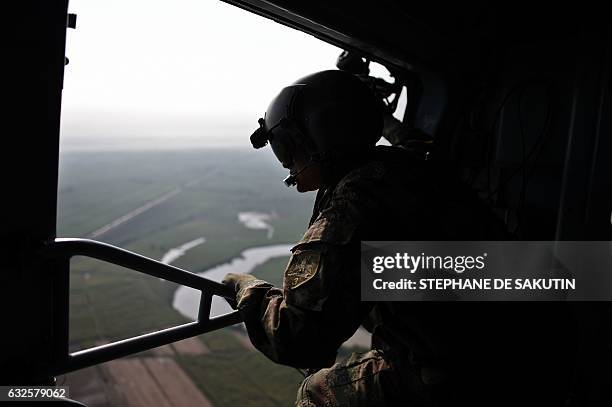 Soldier remains on a helicoper as it overflies Valle del cauca department, Colombia on January 24, 2017. French President Francois Hollande visits...