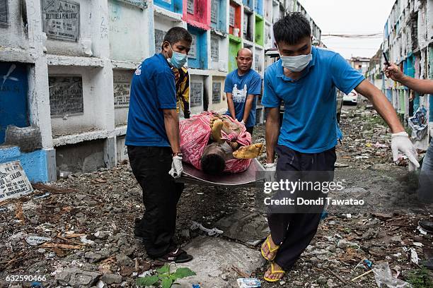 Morgue workers carry an unclaimed body and victim of an extrajudicial killing on January 24, 2017 in Manila, Philippines. More than 6,000 Filipinos...