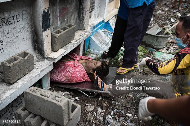 Morgue workers shove unclaimed bodies inside a tomb on January 24, 2017 in Manila, Philippines. Many bodies of victims of extrajudicial killings lay...