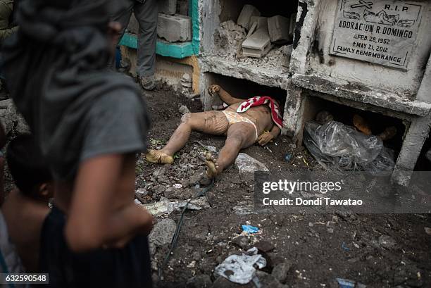 Shanty dwellers living inside the cemetery look at bodies being buried on January 24, 2017 in Manila, Philippines. Many bodies of victims of...