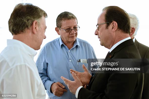 Colombian President Juan Manuel Santos and French President Francois Hollande speak with FARC member Pablo Catatumbo during a visit to a FARC rebel...