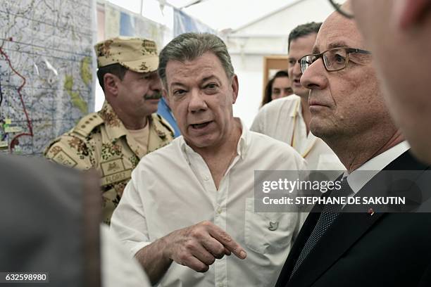 Colombian President Juan Manuel Santos shows a map to French President Francois Hollande in Caldono, Valle del cauca department, Colombia on January...