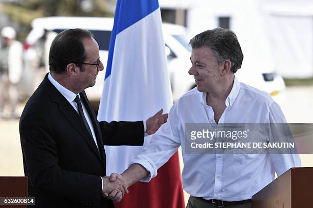 Colombian President Juan Manuel Santos and French President Francois Hollande shake hands after delivering a joint press conference in Caldono, Valle...