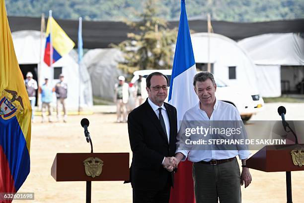 Colombian President Juan Manuel Santos and French President Francois Hollande shake hands after delivering a joint press conference in Caldono, Valle...