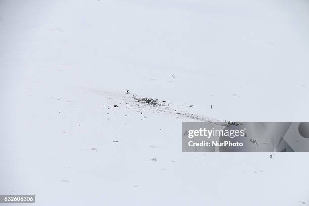 Rescuers work near the wreck of an helicopter following a crash that killed six people, on January 24, 2017 in the mountains near the ski resort of...