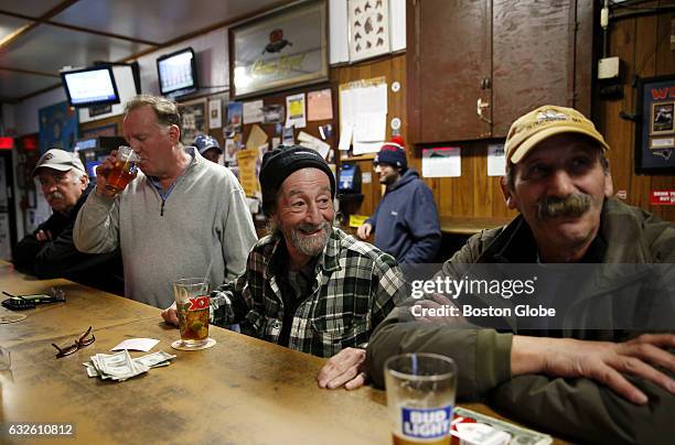 Wayne Hayes, of Gloucester, center, laughs as he tells a story to Nick Grossi, of Gloucester inside the bar Pratty's CAV in Gloucester, MA, where...