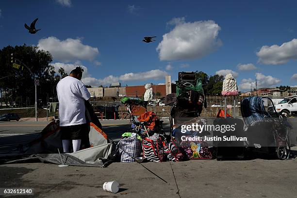 Homeless woman packs up her tent on January 24, 2017 in Los Angeles, California. According to a 2016 report by the U.S. Department of Housing and...