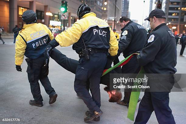 Police arrest a protestor who was sitting in the street blocking traffic demonstrating against President Donald Trump during the evening rush hour in...