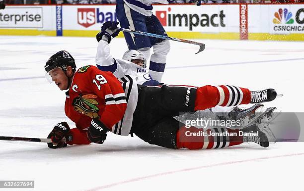 Jonathan Toews of the Chicago Blackhawks hits the ice after being pulled down by Alex Killorn of the Tampa Bay Lightning at the United Center on...