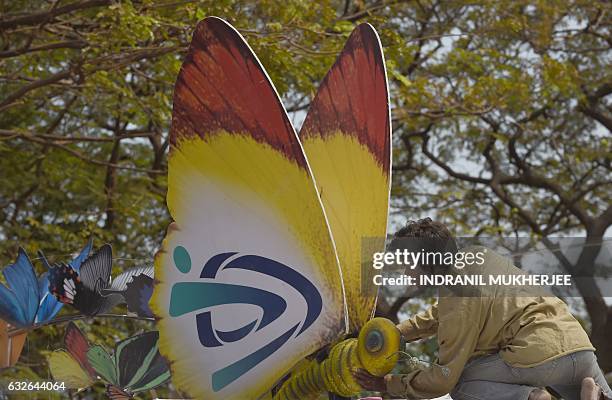 Indian worker adjusts a replica of a butterfly on a tableaux on the eve of the country's 68th Republic Day celebrations in Mumbai on January 25,...