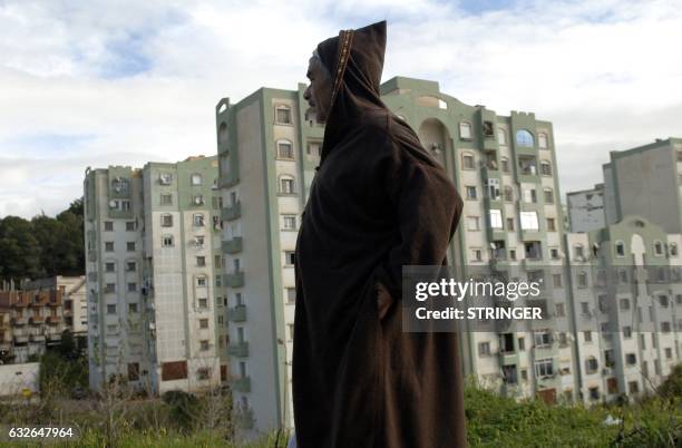 An Algerian man walks in one of the many new residential districts outside the capital Algiers on January 23, 2017. Experts say urban violence is on...