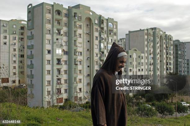 An Algerian man walks in one of the many new residential districts outside the capital Algiers on January 23, 2017. Experts say urban violence is on...