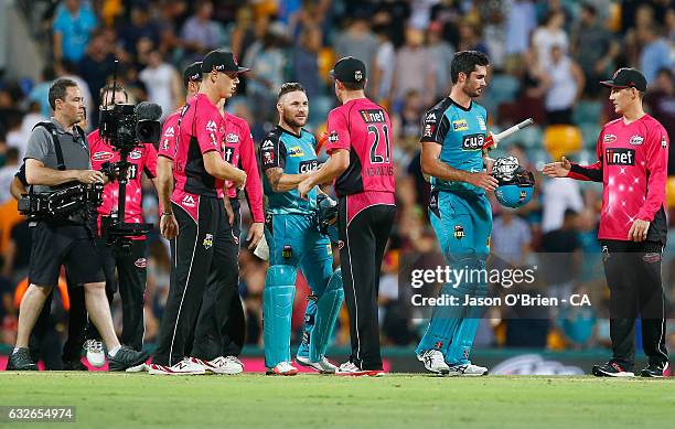 Moises Henriques of the Sixers shakes hands with Brendon Mcullum during the Big Bash League semi final match between the Brisbane Heat and the Sydney...