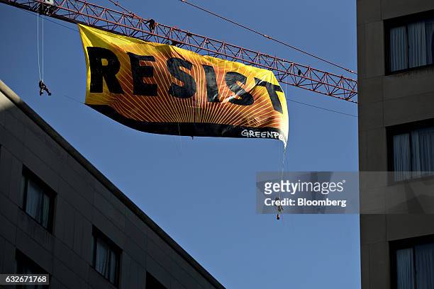 Greenpeace activists hang from a construction crane with a banner that reads "Resist" in Washington, D.C., U.S., on Wednesday, Jan. 25, 2017. The...