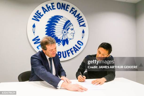 Belgium's first division football club KAA Gent's Japanese new forward Yuya Kubo signs his contract next to Gent's managing director Michel Louwagie...