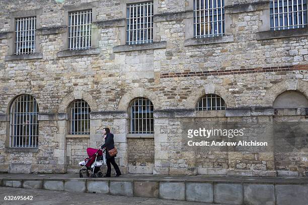 Woman pushed her baby pushchair along a ramp outside Malmaison Boutique Hotel in Oxford Castle Quarter, England, United Kingdom. The boutique hotel...