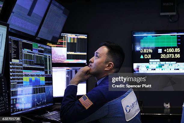 Traders work on the floor of the New York Stock Exchange as the Dow Jones industrial average closed above the 20,000 mark for the first time on...