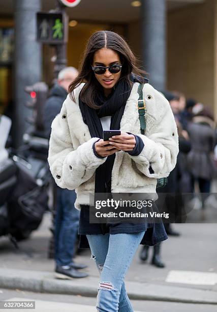 French model Cindy Bruna wearing a white fur jacket, black scarf, green bagpack outside Elie Saab on January 25, 2017 in Paris, Canada.